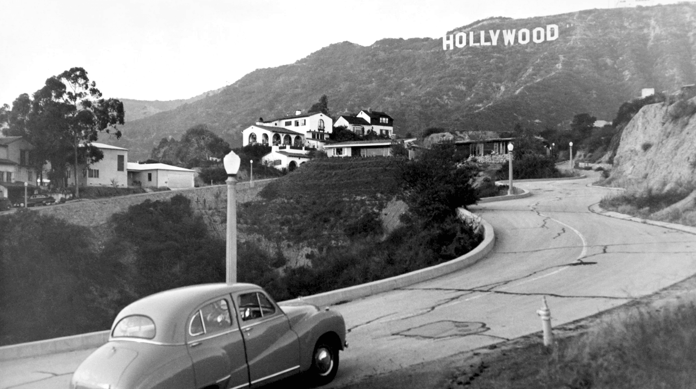 Old 1940's can on driveway with Hollywood sign in distance